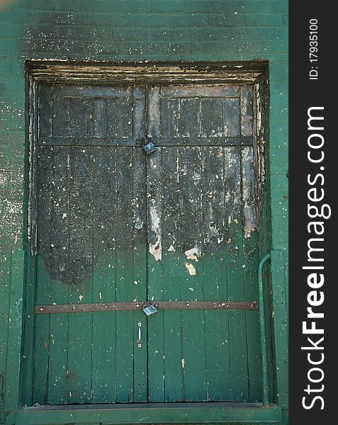 An old burnt green door with flaking paint