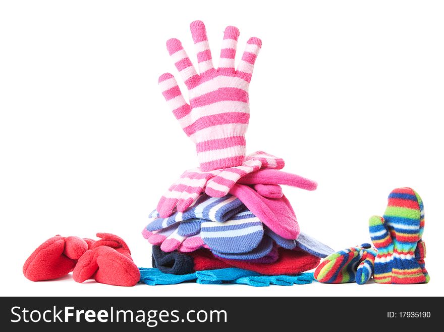 Pile of woollen garments and pink glove in greeting gesure at the top. Isolated over white. Pile of woollen garments and pink glove in greeting gesure at the top. Isolated over white