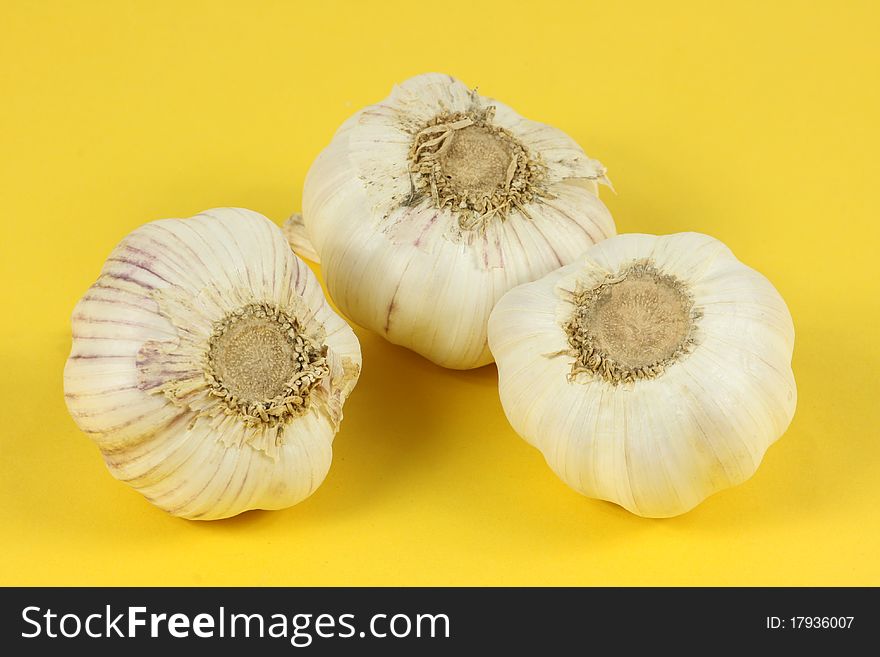 Three garlic on a yellow background