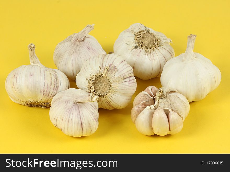 A pile of garlic on a yellow background