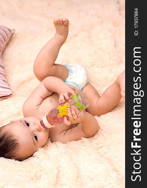 Little caucasian boy drinking from the bottle