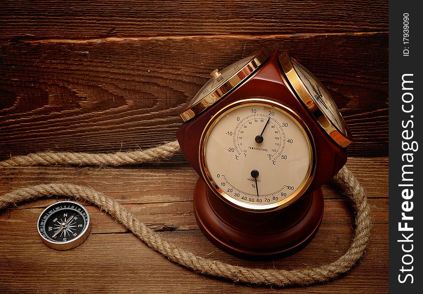 Old termometer, and compass on wood background. Old termometer, and compass on wood background