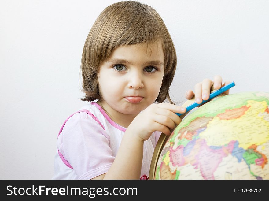 Little girl playing with a terrestrial globe, isolated on white. Little girl playing with a terrestrial globe, isolated on white