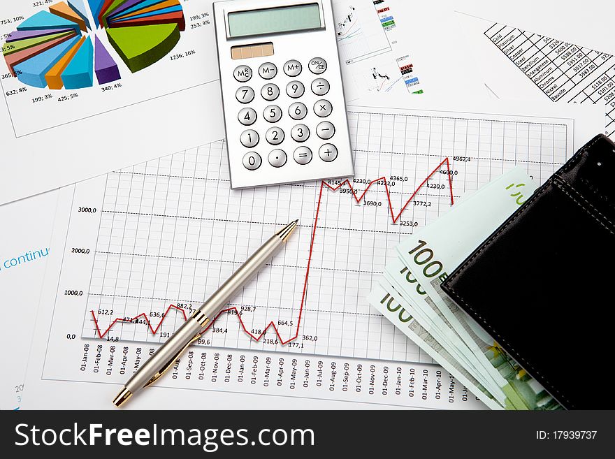 Financial charts and graphs on table with pen