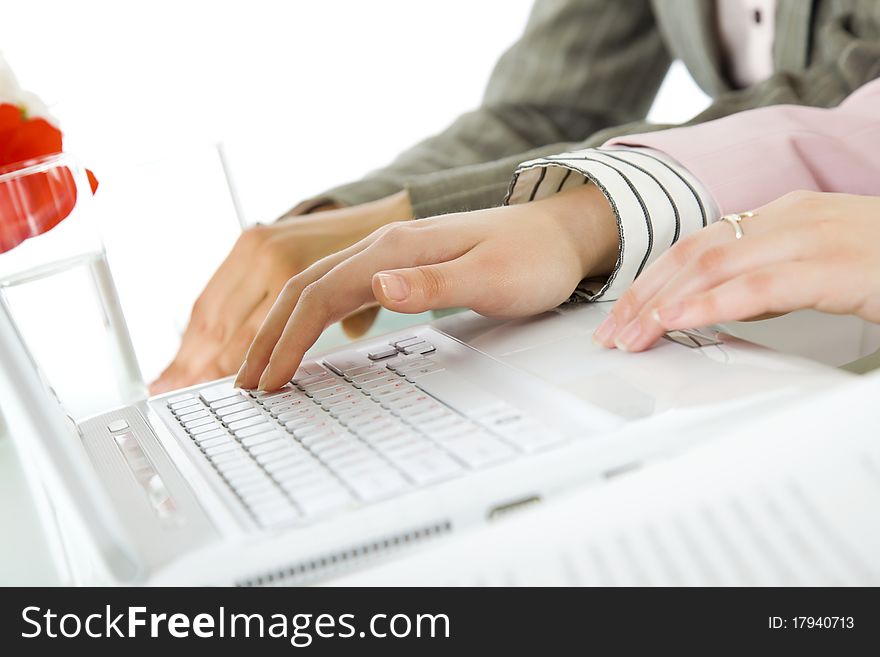 Close-up of female hands using ciralised laptop on desk. Close-up of female hands using ciralised laptop on desk