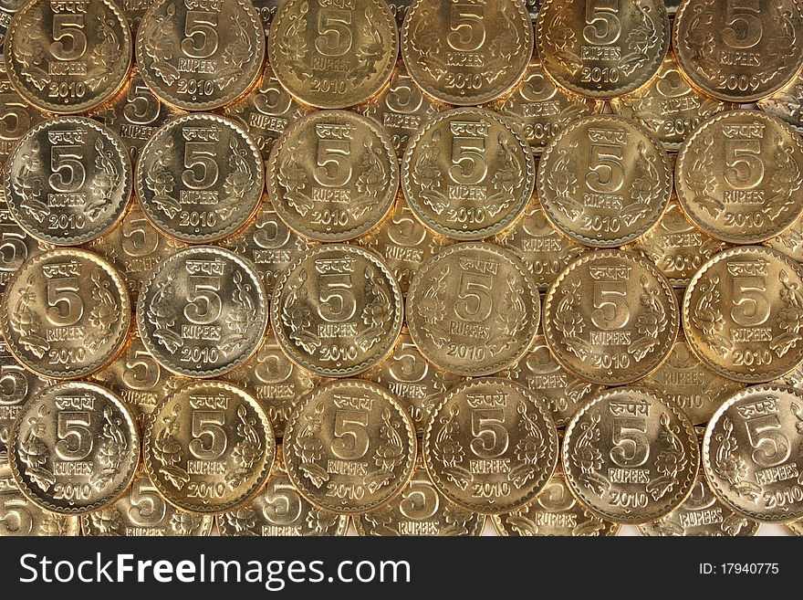 A collection of scattered indian currency 5 rupee coins. A collection of scattered indian currency 5 rupee coins