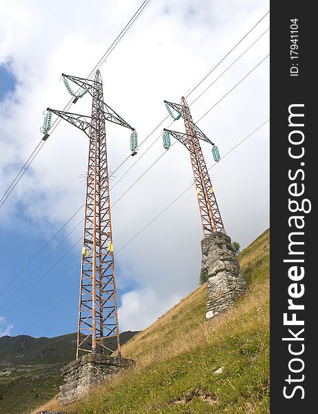 High-tension towers in the mountains and the sky blue. High-tension towers in the mountains and the sky blue