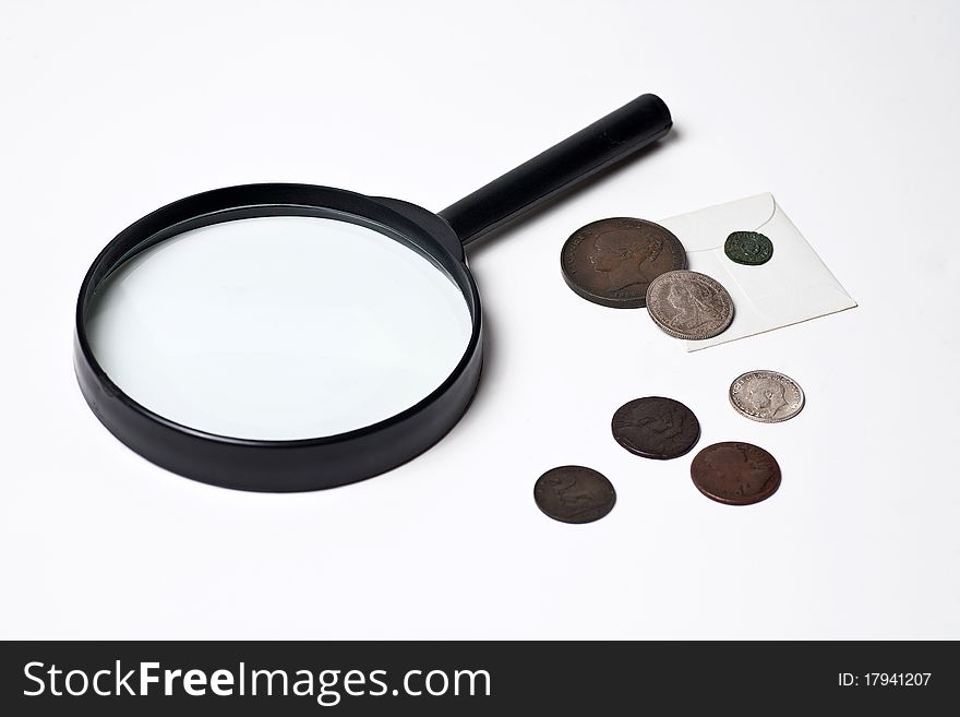Old Coins and Magnifying Glass