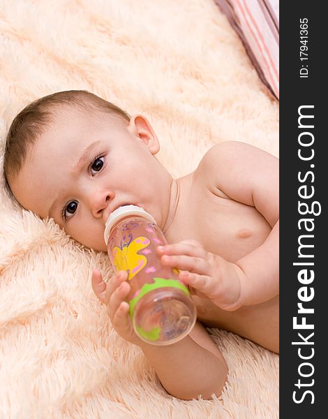 Little caucasian boy drinking from the bottle