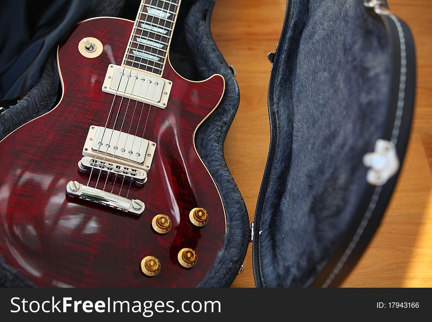 Electric guitar in the black open case with strings and bridge