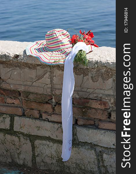 Woman's hat on a brick protection ashore sea