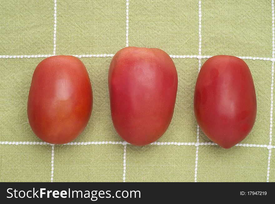 Fresh Trio of Roma Tomatoes on Green Kitchen Towel.