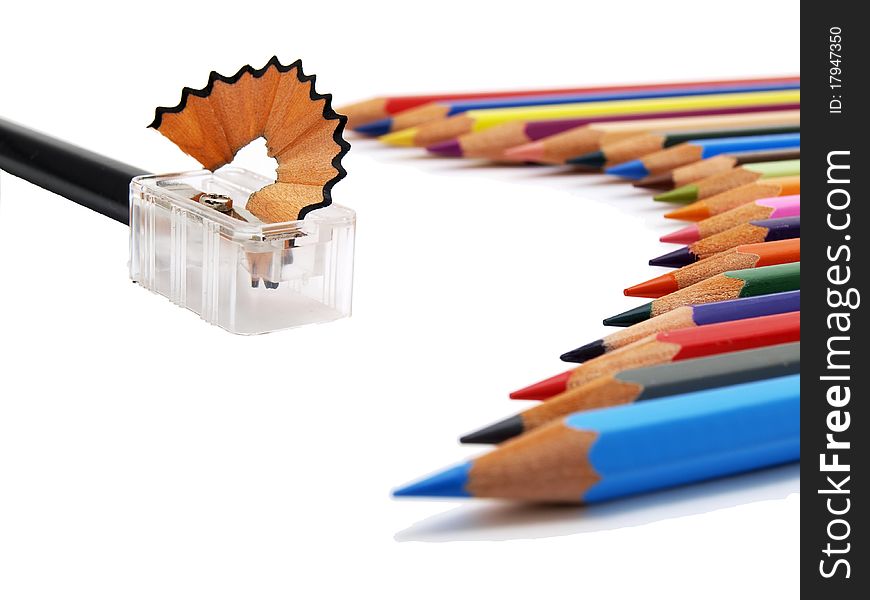 Lower view of colored pencils and sharpener on white background