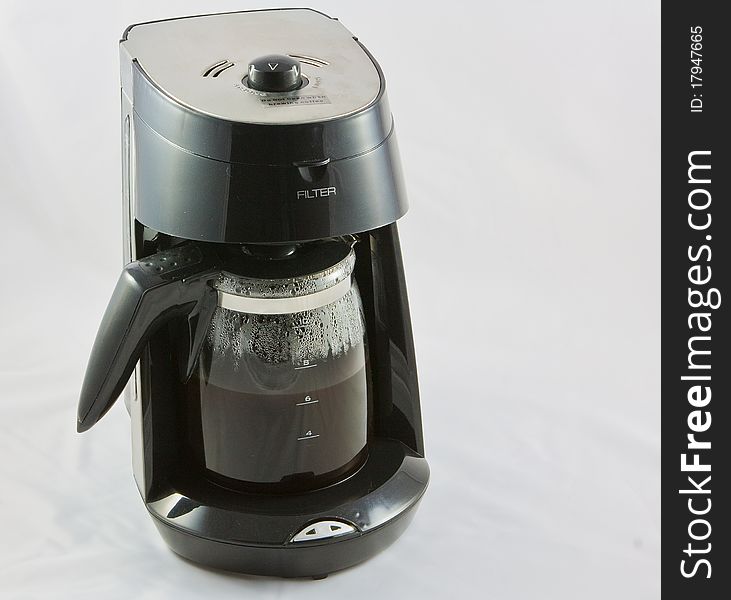 A black coffee grinder and a bowl of freshly ground coffee. A black coffee grinder and a bowl of freshly ground coffee