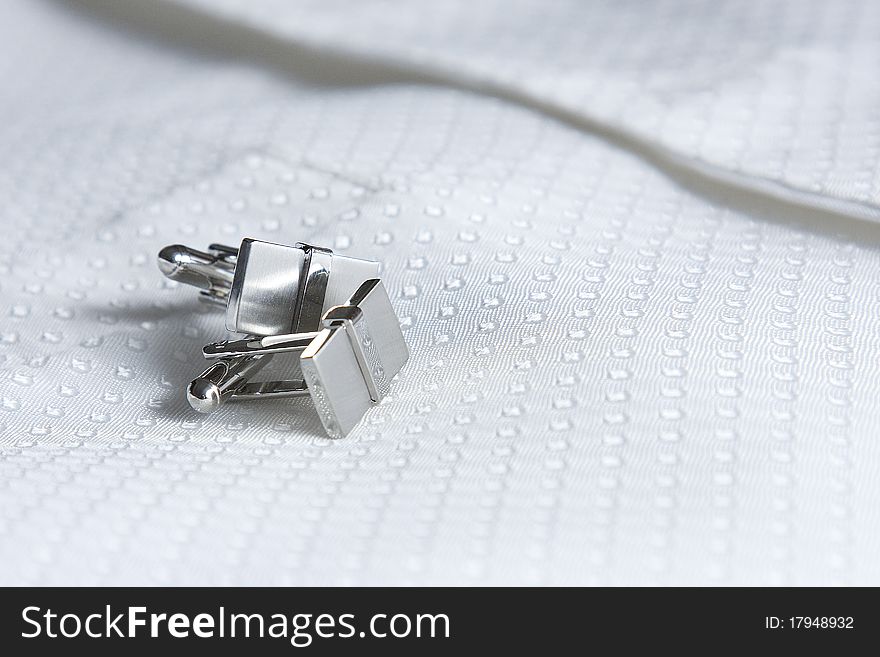 The grooms cufflinks rest on his waist coat.