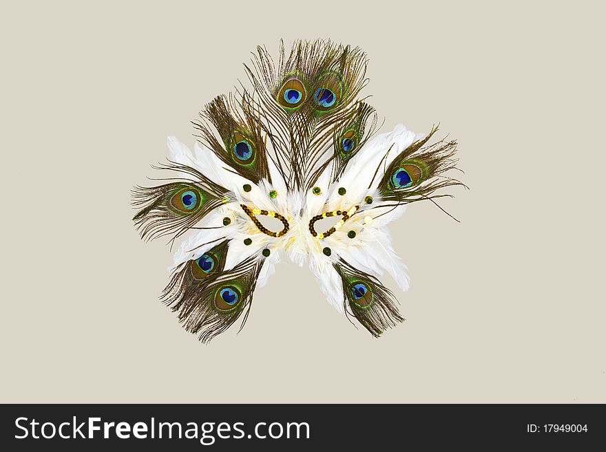 White and green carnaval mask made with feathers isolated on light cream