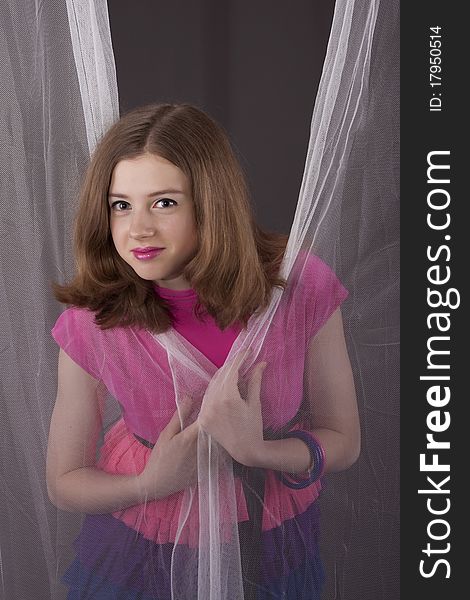 Portrait of the teenager girl between white curtains. Portrait of the teenager girl between white curtains