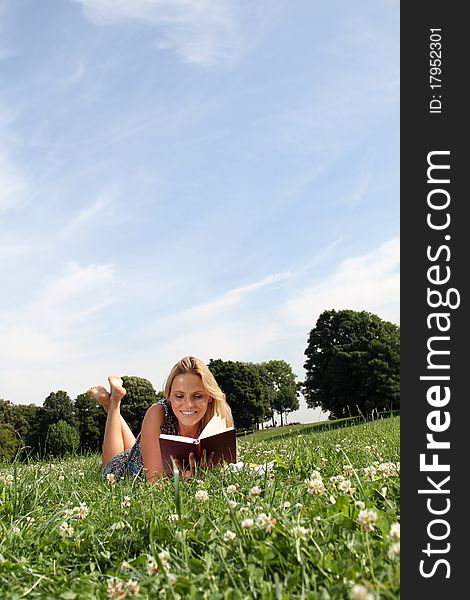 Beautiful blond woman enjoying her free time outside reading a good book. Beautiful blond woman enjoying her free time outside reading a good book