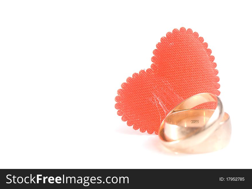 Red heart and wedding rings, is isolated on a white background. Red heart and wedding rings, is isolated on a white background