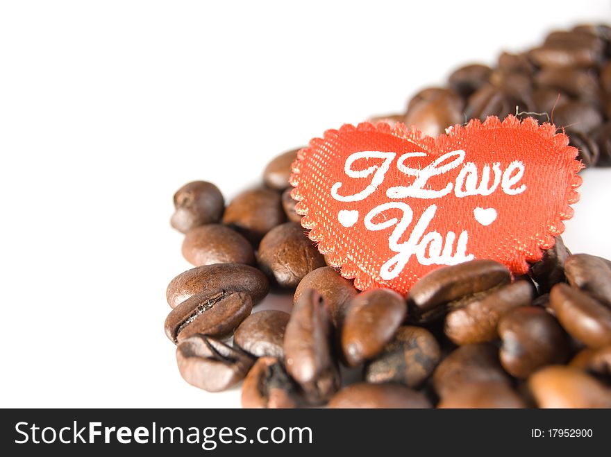 Red heart in the coffee beans, is isolated on a white background. Red heart in the coffee beans, is isolated on a white background