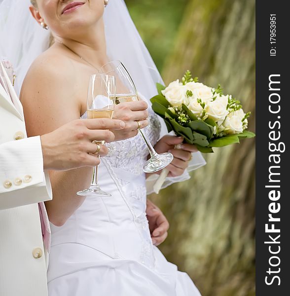 Bride and fiance are holding wedding glass