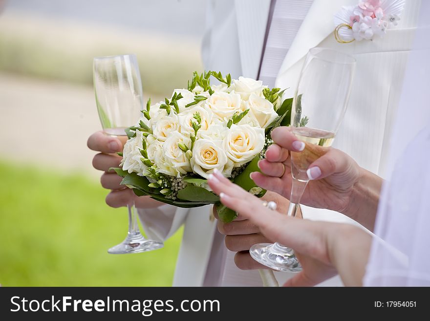 Bride checks her nails while fiance holds wedding bouquet. Bride checks her nails while fiance holds wedding bouquet