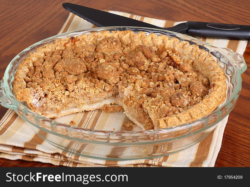 Sliced whole apple crumb pie in a pie dish