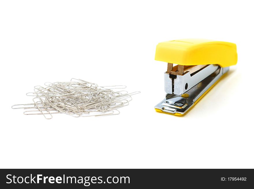 Photo of the Yellow stapler and paperclips on white background