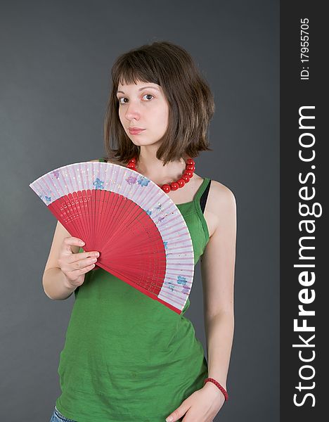 Girl with a fan on a black background