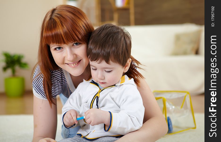 Mother playing with her little son at home on the floor. Mother playing with her little son at home on the floor