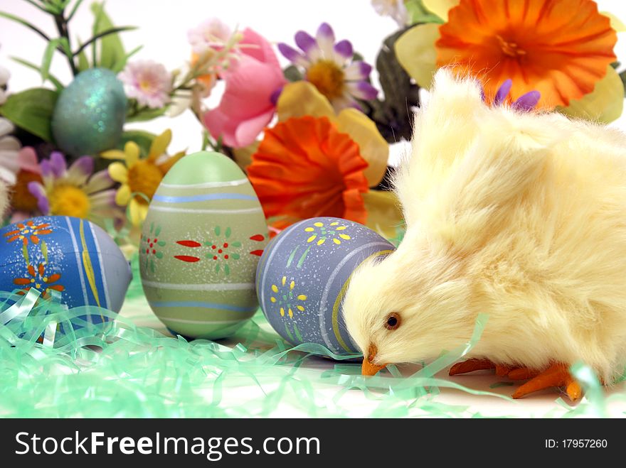 A chick with some easter eggs and flowers. A chick with some easter eggs and flowers.