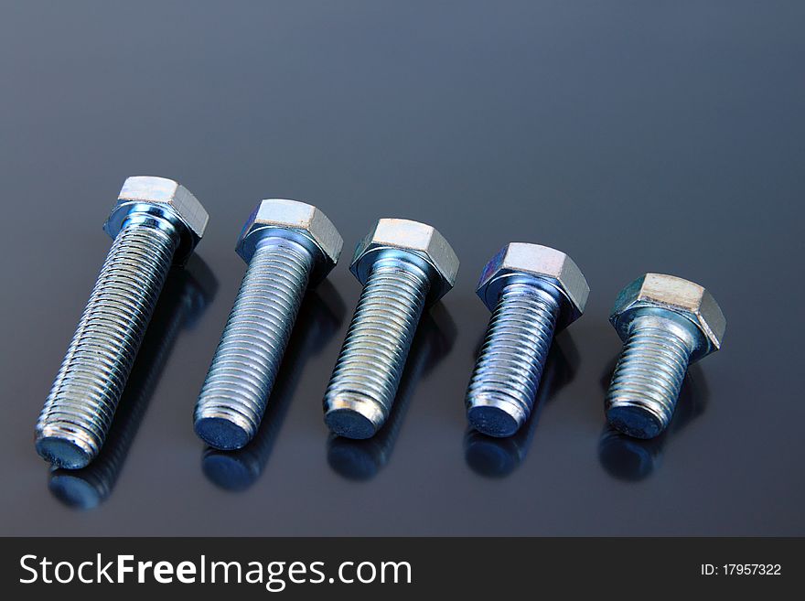 Metal bolts on a grey background