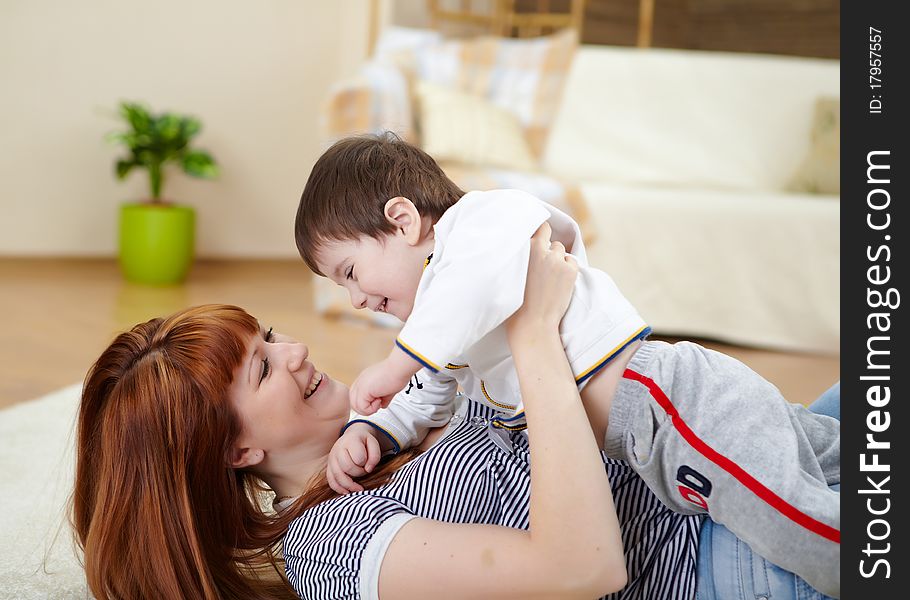 Mother playing with her little son at home on the floor. Mother playing with her little son at home on the floor