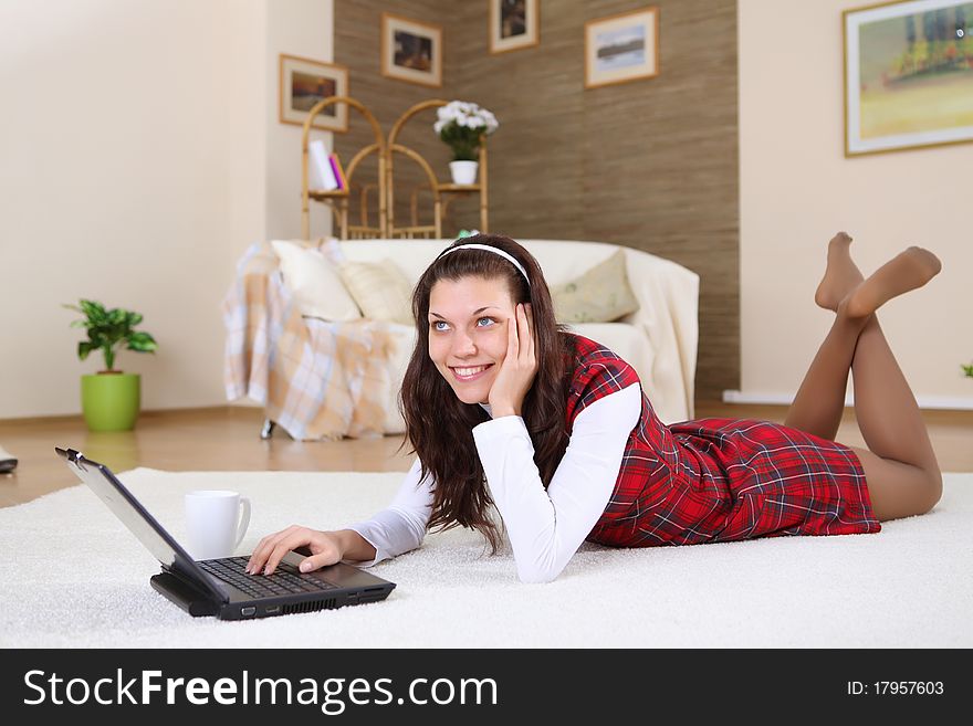 A young girl with a lap top at home on the floor of a living room