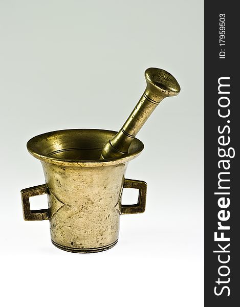 Old brass mortar with pestle on white
