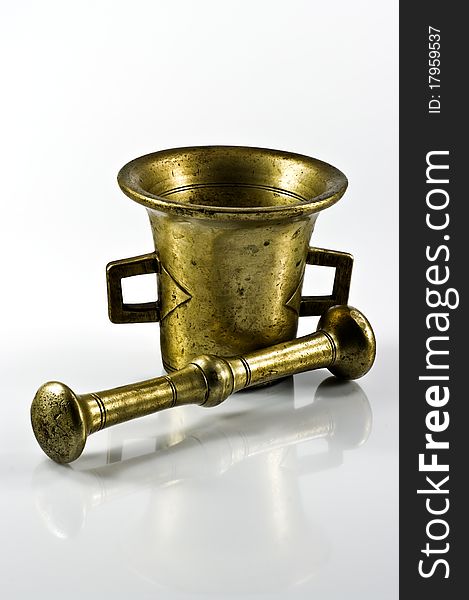 Old brass mortar with pestle on white