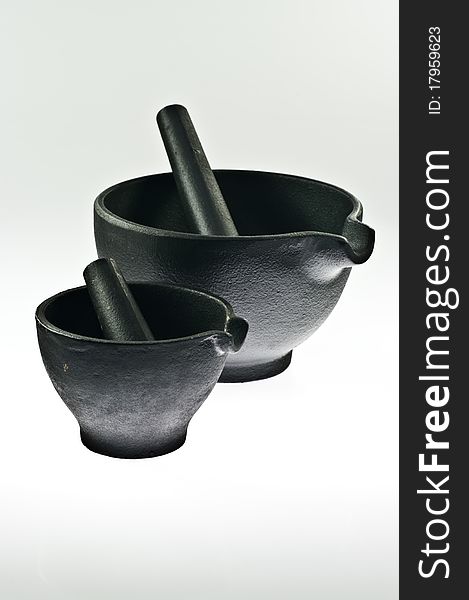 Two iron mortars with pestles on white