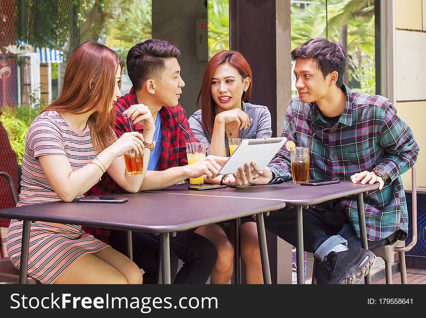 Portrait of young people using digital tablet while spending leisure time in restaurant. Portrait of young people using digital tablet while spending leisure time in restaurant