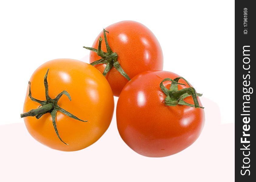 Red ana orange tomatoes with drops of water isolated on the white background