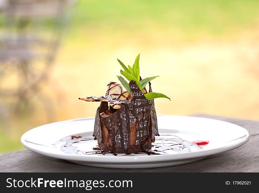 Beautifully decorated chocolate mousse served on white plate with chocolate shards printed with musical notes. Beautifully decorated chocolate mousse served on white plate with chocolate shards printed with musical notes