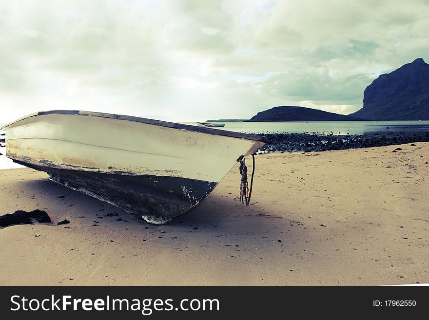 An old boat found on the beach of a unique sea. A moutain comes out directly from the sea itself. An old boat found on the beach of a unique sea. A moutain comes out directly from the sea itself.