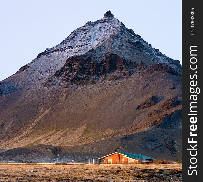 Lava mountain and small house in Icelandic Arnarstapi town. Lava mountain and small house in Icelandic Arnarstapi town.