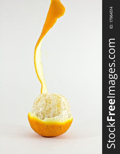 An orange half peeled over white background. An orange half peeled over white background