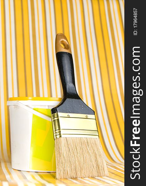 Container with a paint and a painting brush on a bright striped background. Container with a paint and a painting brush on a bright striped background
