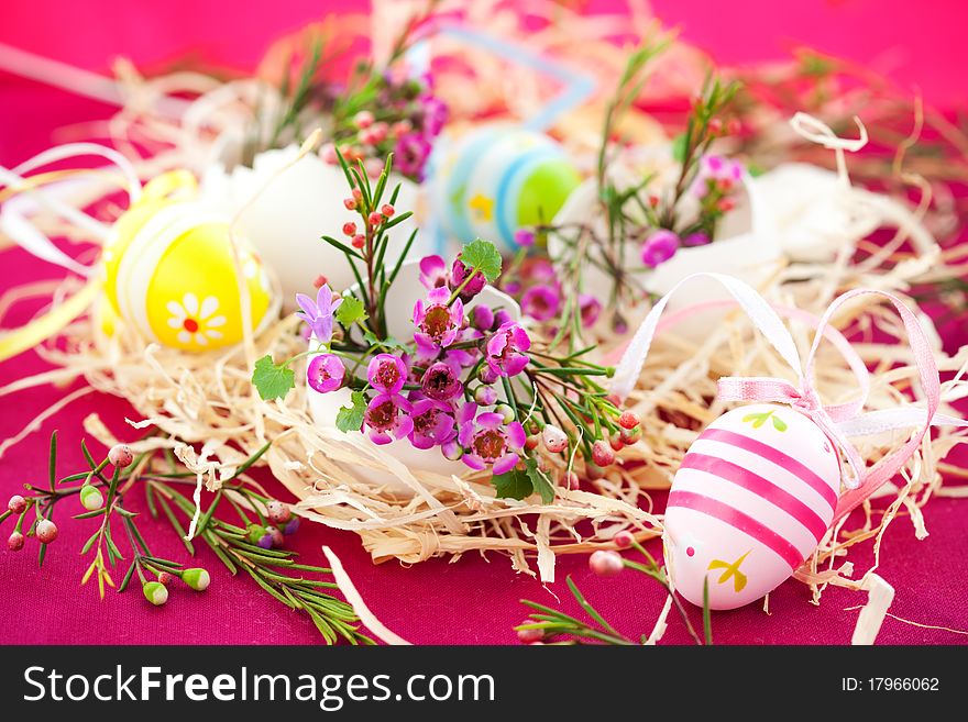 Easter decoration: nest with spring pink flowers in eggshells and easter eggs
