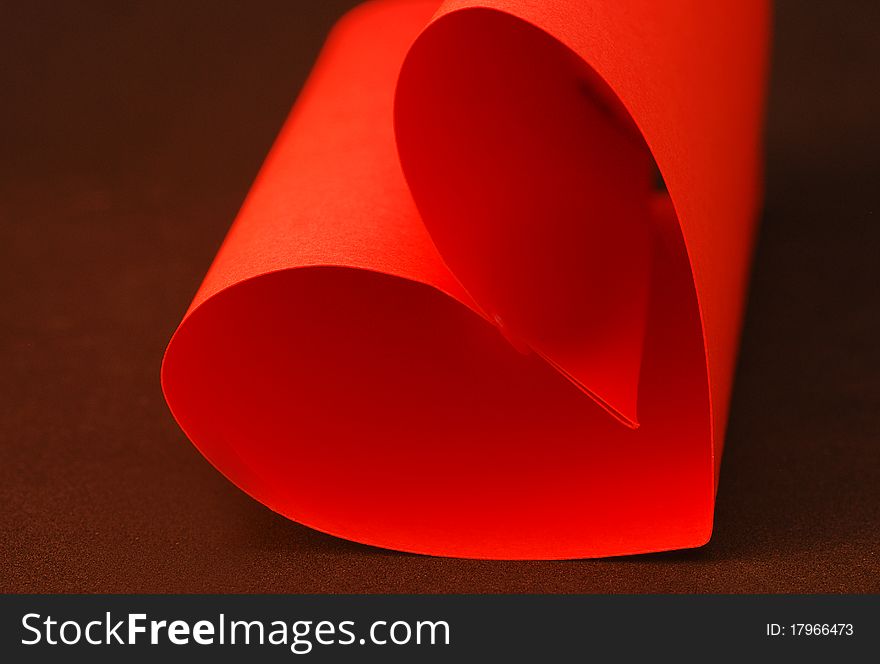 A red paper heart with a black background. A red paper heart with a black background