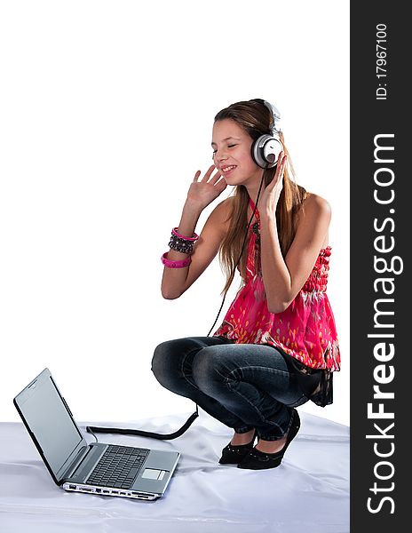 The cheerful girl in ear-phones and with the laptop listens to music. The cheerful girl in ear-phones and with the laptop listens to music