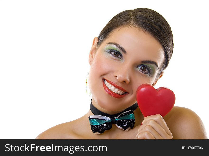 Cute young woman holds a heart symbol to her face