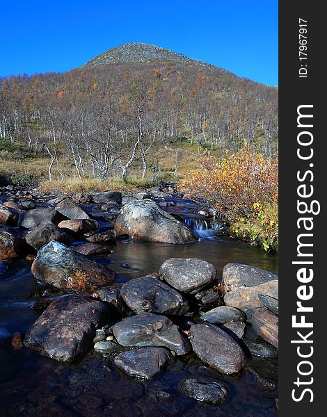 Flowing stream with a mountain top in the background. Flowing stream with a mountain top in the background