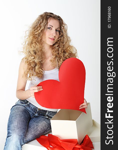 Blond girl with big valentine card and opened gift box